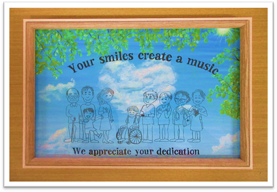 「~Your Smile Create a Music~ あなた方の笑顔は音楽を創り出します」「~We appreciate Your Dedication~献身的なお仕事に感謝しています」とメッセージが描かれています。